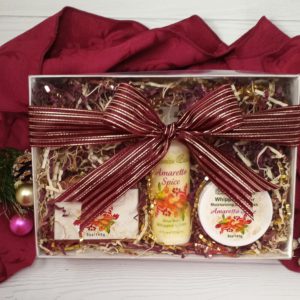 amaretto spice 3 piece gift set box with burgundy and gold stripped bow, with holiday burgundy towel background